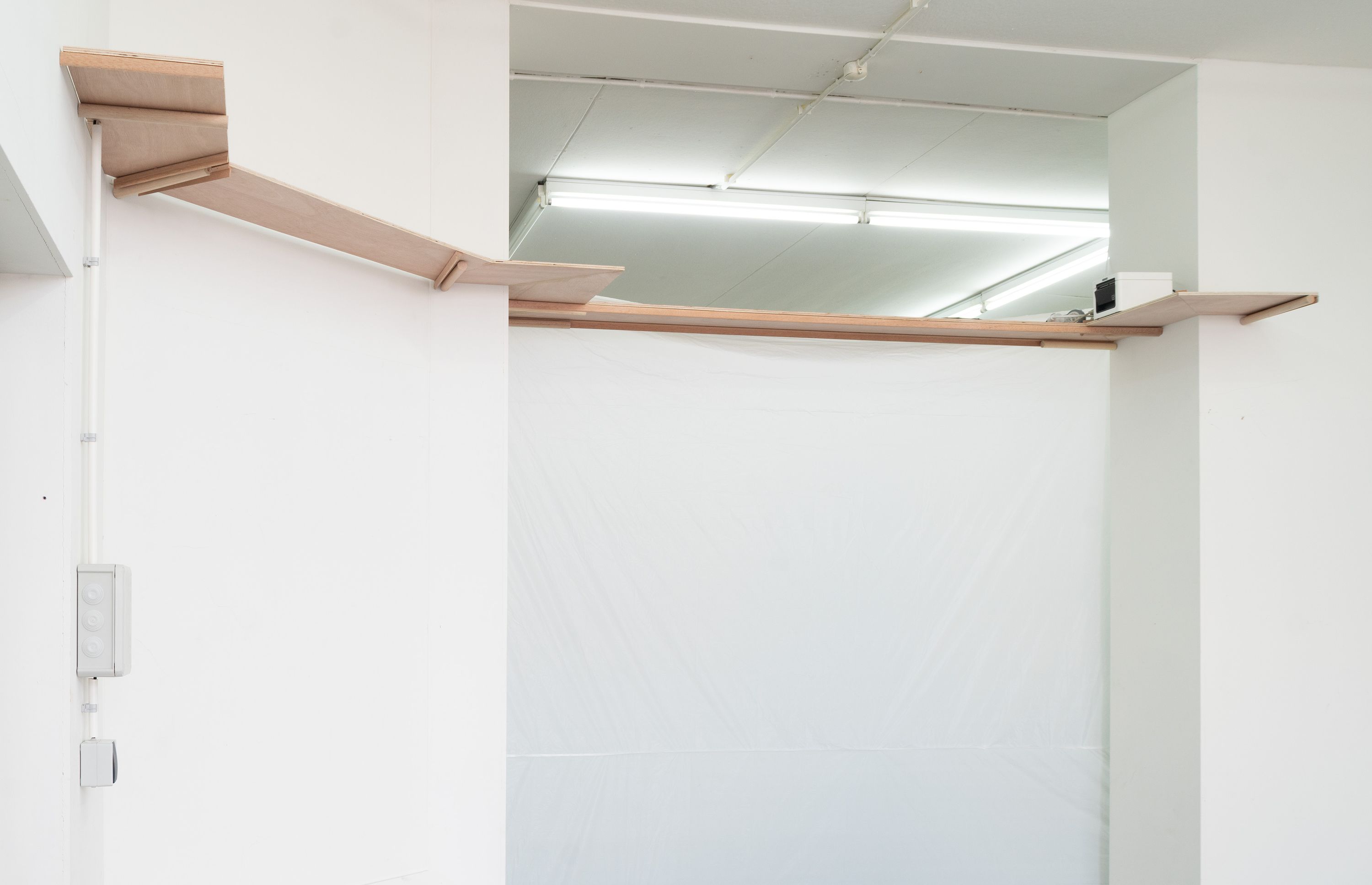 Marissa Lee Benedict and David Rueter, a conversation between machines about Mallarmé (regarding the state of the gallery lights), 2023, Wooden shelf, receipt printer, thermal paper, wiring and conduit, custom software, annotated text file containing Stéphane Mallarmé's poem "Un coup de dés jamais n'abolira le hasard," Large Language Model (LLM) cloud service account, single-board computer.